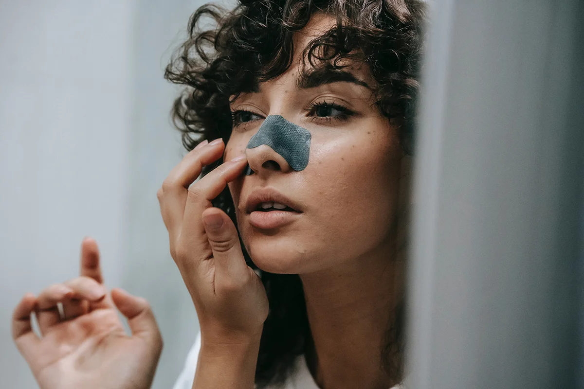 Applying nose strip to remove blackheads